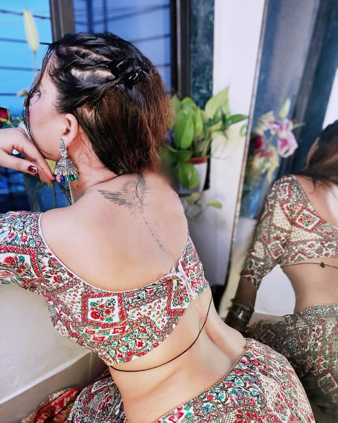 Anjita Leans Against A Wall Under Pink Lighting