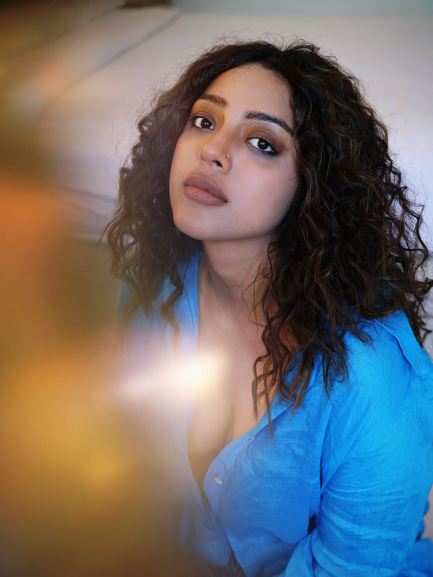 Deviyani Sharma poses stylishly in a blue shirt and ripped jeans.