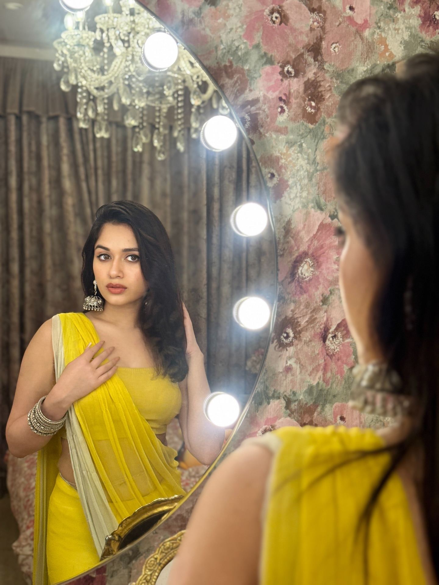 Jannat Zubair looking in a lighted mirror.