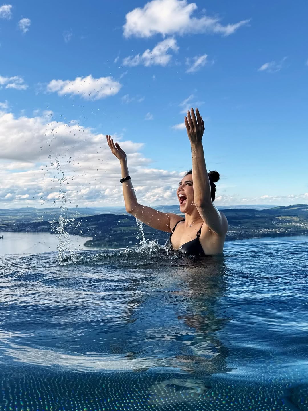 The actress flaunts her toned curves by the infinity pool edge.