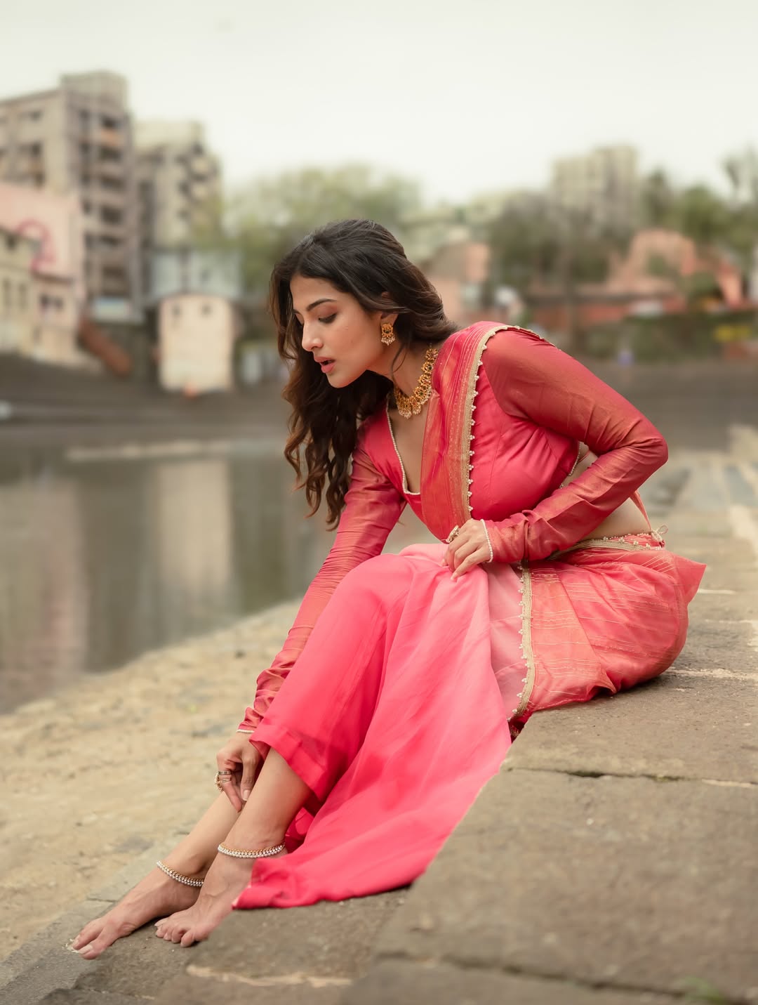 Miloni Jhonsa looks down, showcasing her gold jewelry and silver anklet.