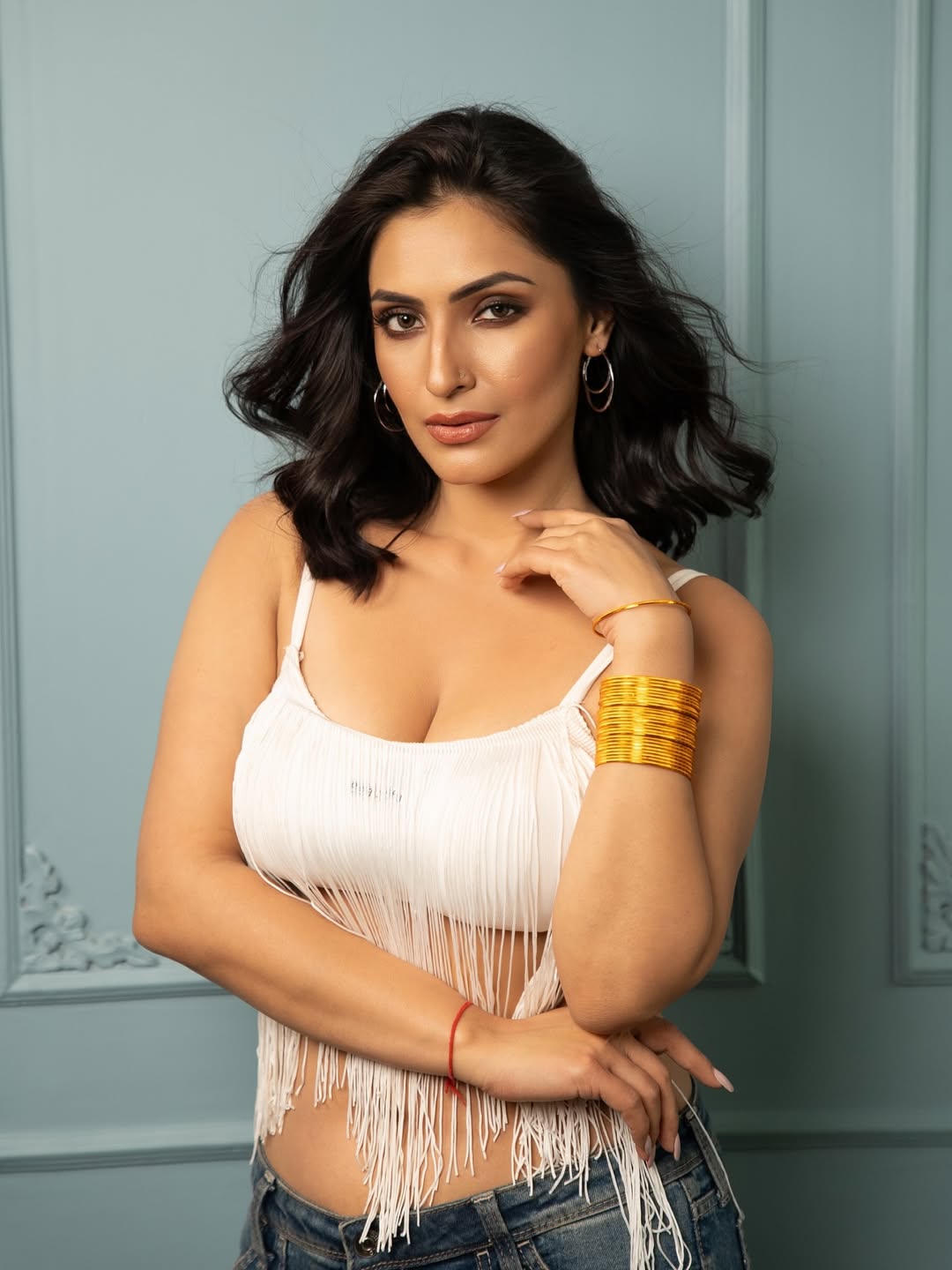 She looks gorgeous posing with one hand resting gently on her arm.