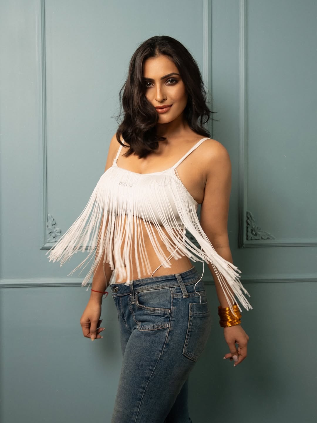 The actress flaunts her incredible figure in jeans and a fringed top.