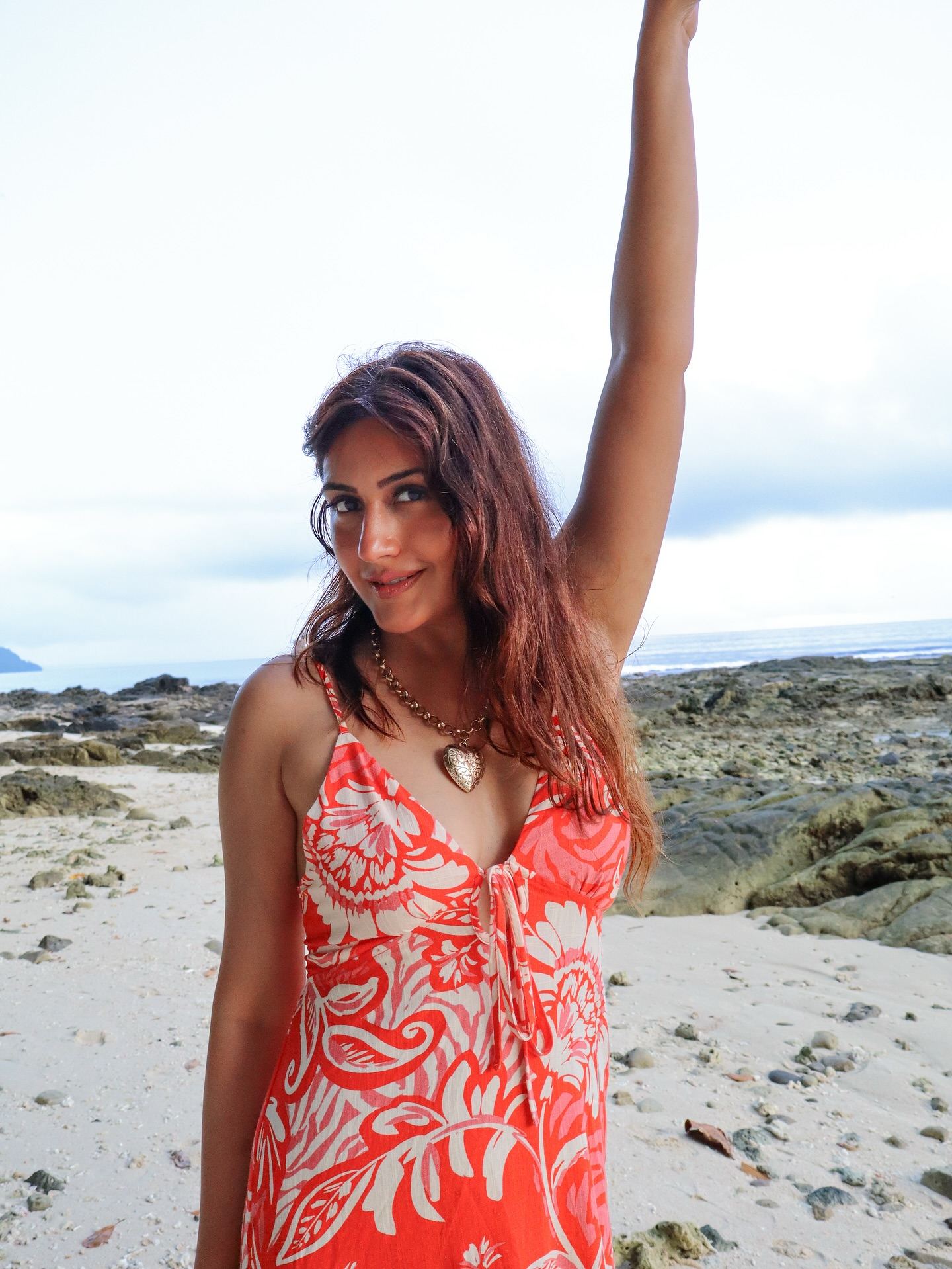 Surbhi Chandna poses on the beach in a red dress.