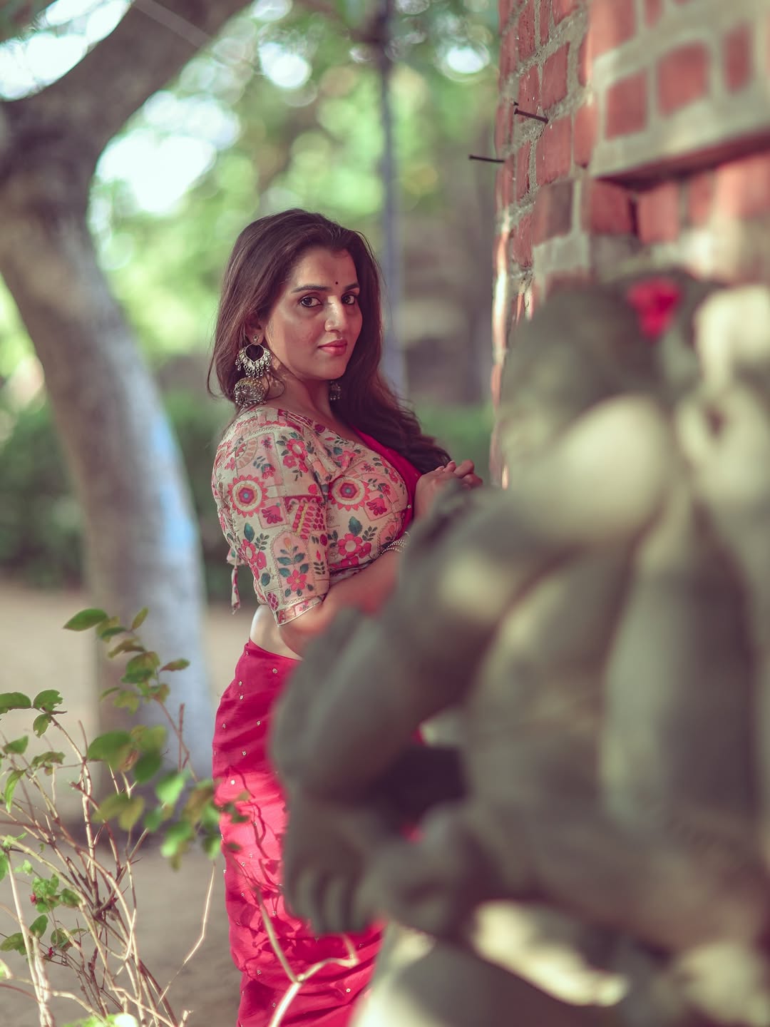 Utkarshica looks serene leaning against a brick wall in her ethnic attire.