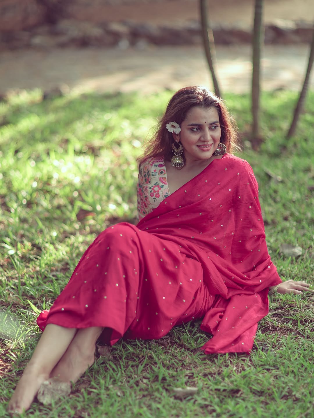 A playful Utkarshica Srivastava peeks from behind a rustic wooden door.