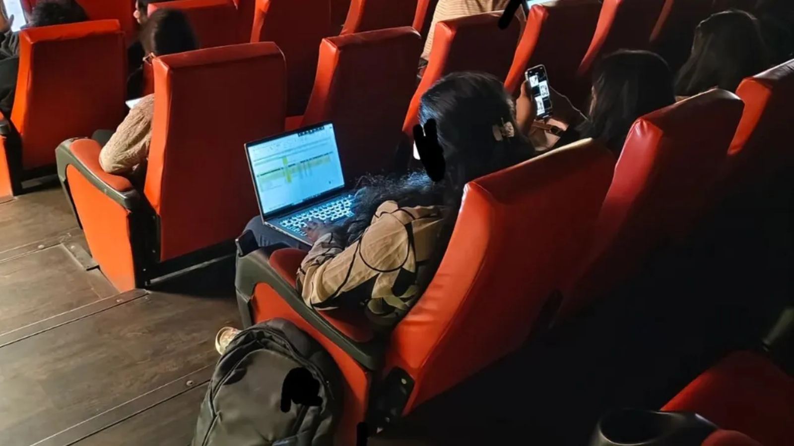Woman working on laptop in theatre