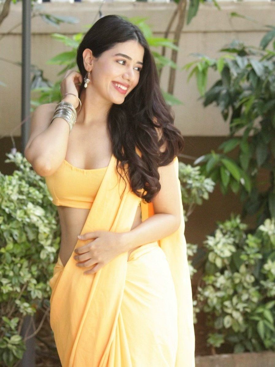 The Actress Poses Gracefully By A Tree Trunk