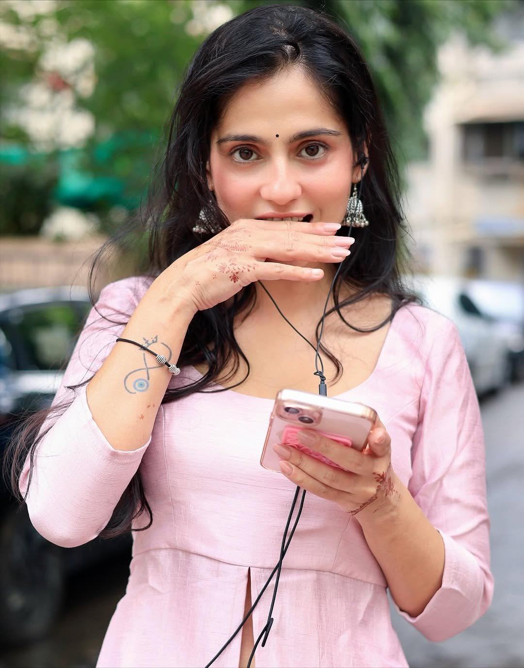 The Actress Holds Phone With Wired Earphones