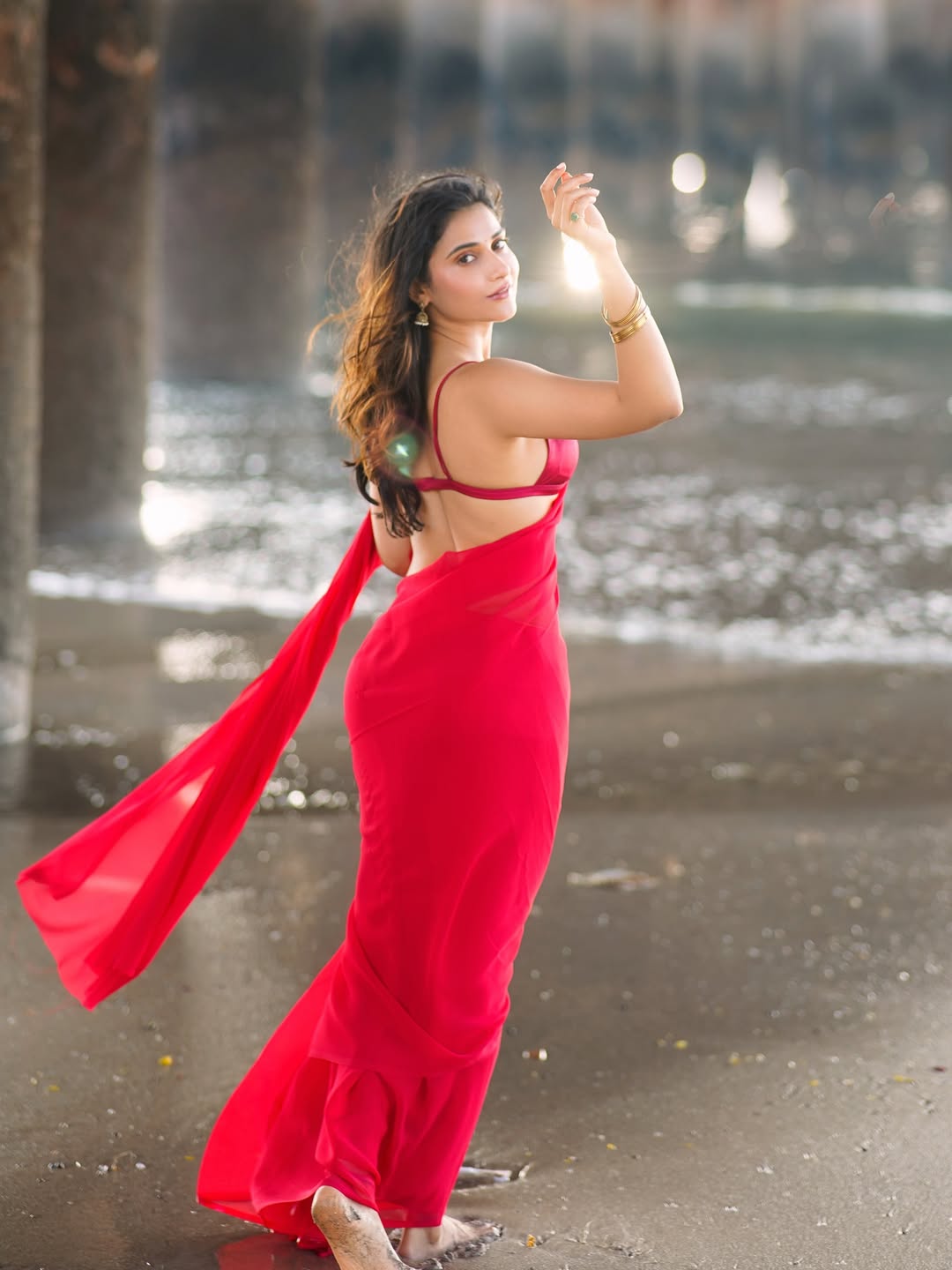 Prisha Singh Poses Under Pier In Red Saree Photo