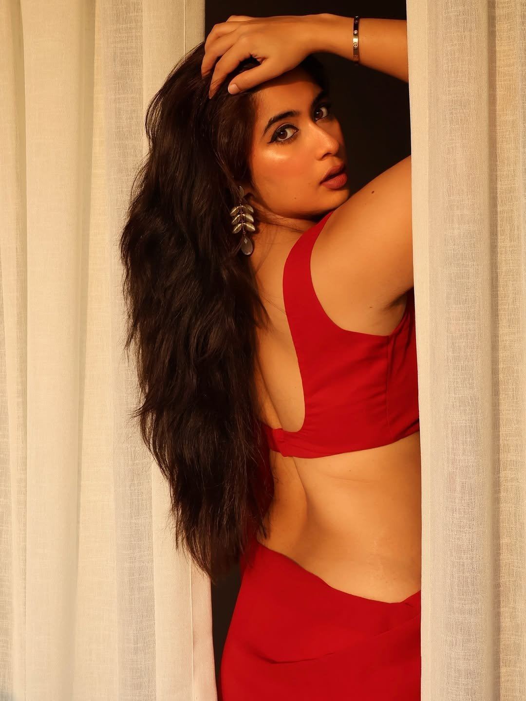 Nikita Sharma Flaunting Toned Waist In Red Saree