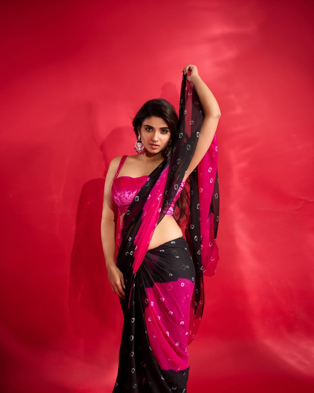Pragya Nagra Radiant Poses Against Red Backdrop.