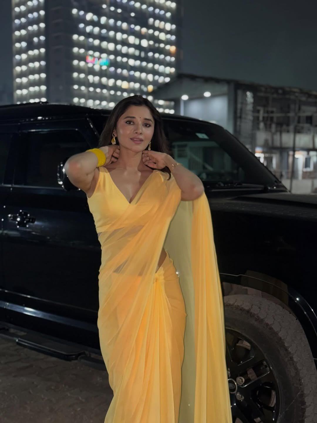 Kanika Mann posing in yellow saree near SUV