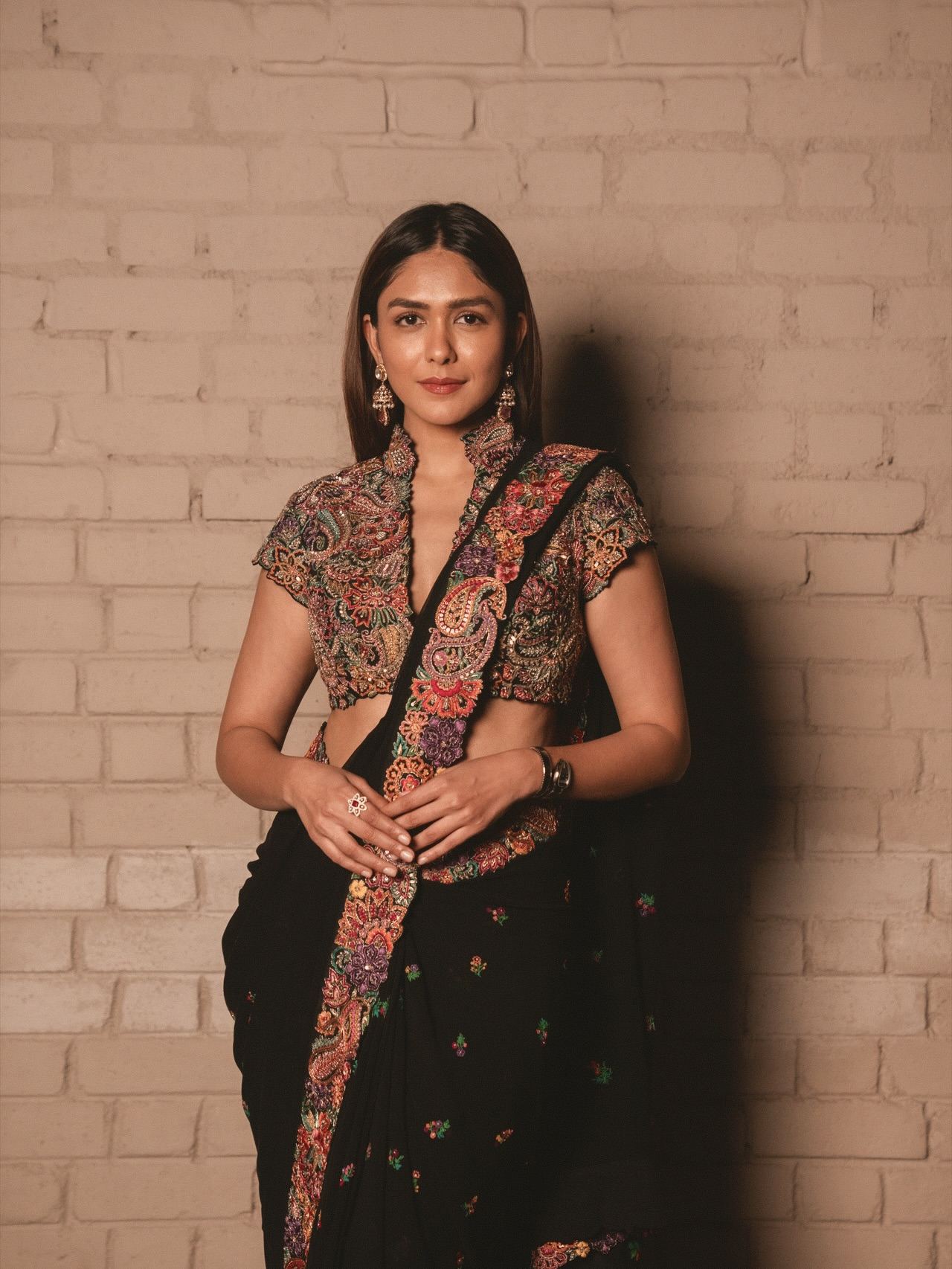 Stylish Mrunal Thakur Leaning Against A Brick Wall