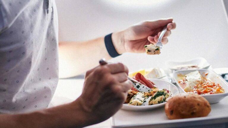 Passenger eating chicken on flight