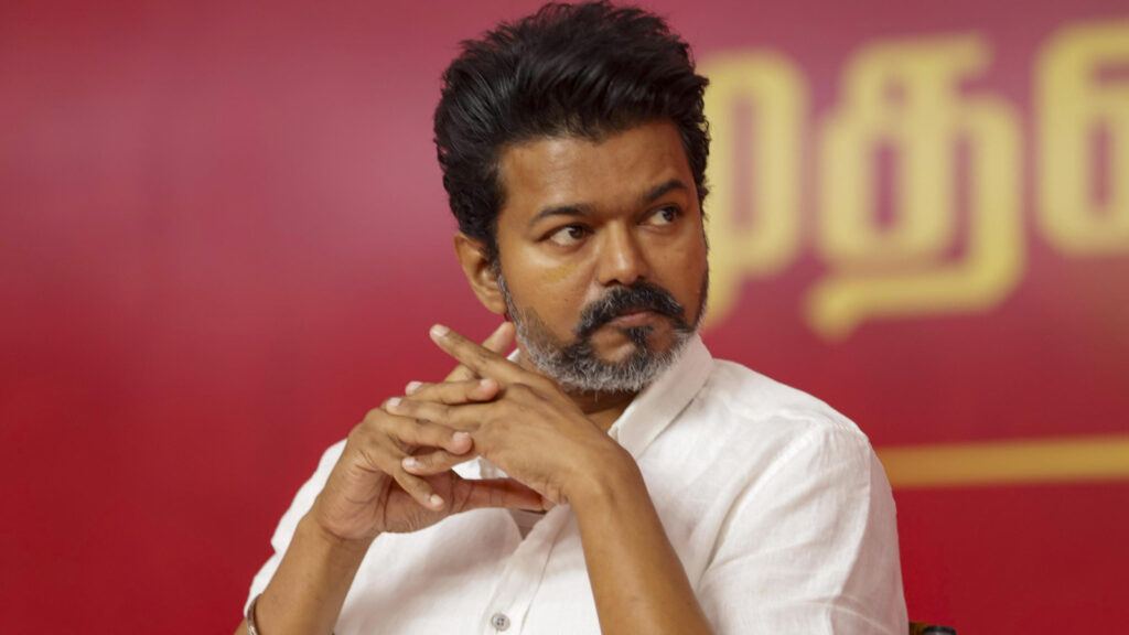 Thalapathy Vijay with TVK party backdrop highlighting debate on fan support and political success in Tamil Nadu elections.