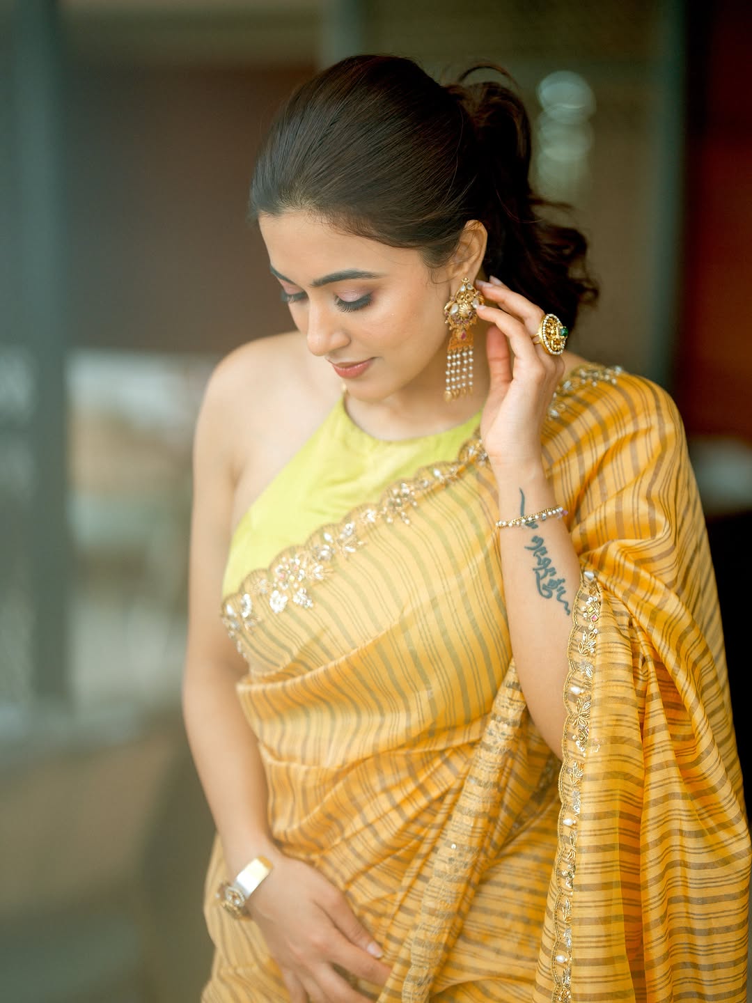 Anju Kurian Touching Gold Earring With A Smile