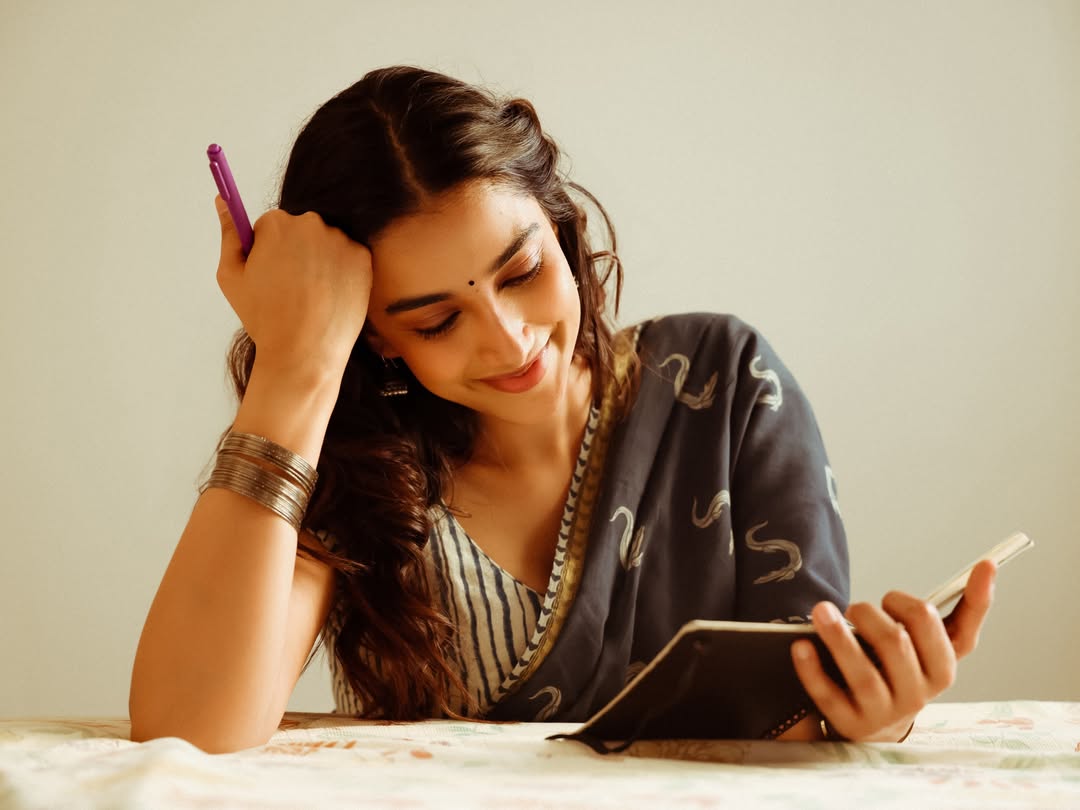 Meenakshi Chaudhary Reading Book On Bed Smiling