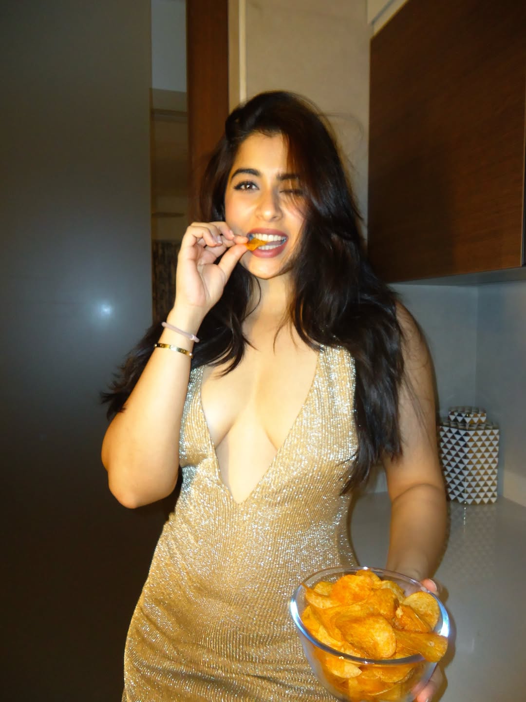 Nikita Sharma Winking Happily Holding Potato Chips