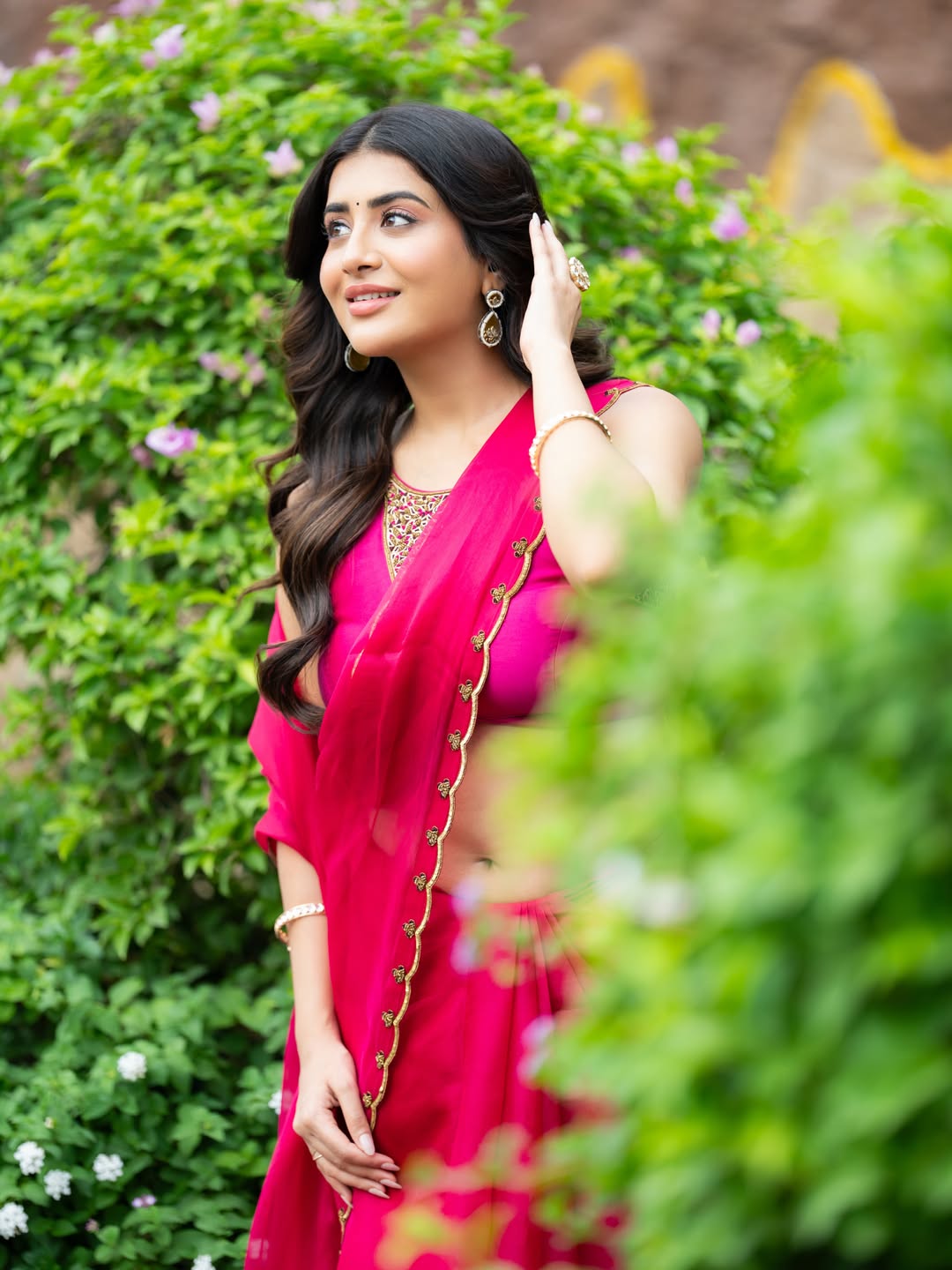 Rashi Singh Leaning Gracefully Near Garden Bushes