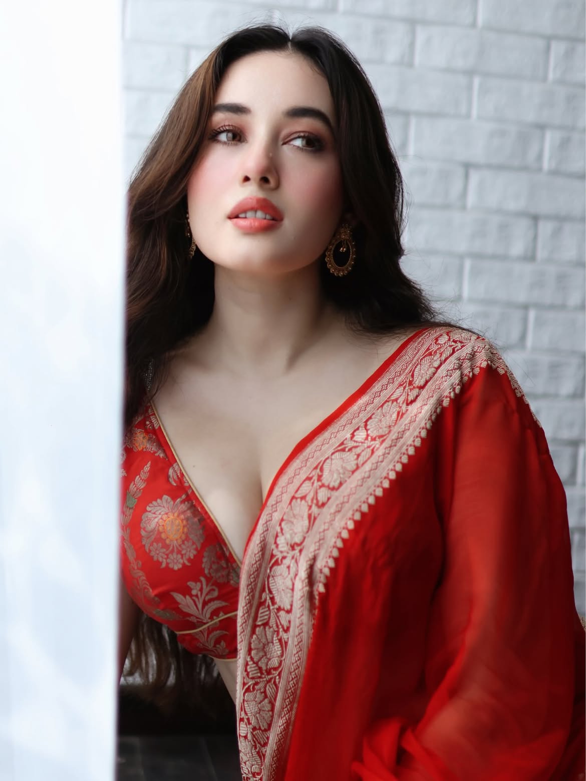 Graceful Window Pose In Vibrant Red Saree Look