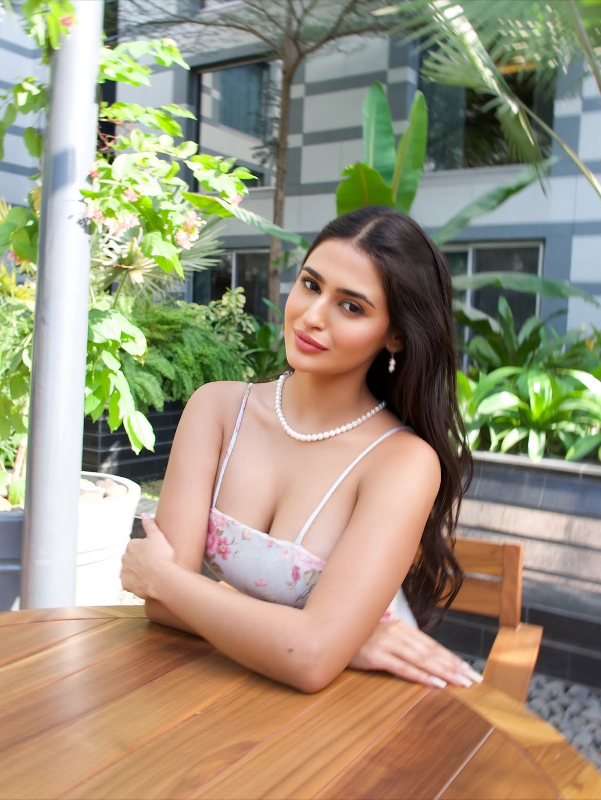 Prakriti Pavani Sitting Elegantly At Wooden Table