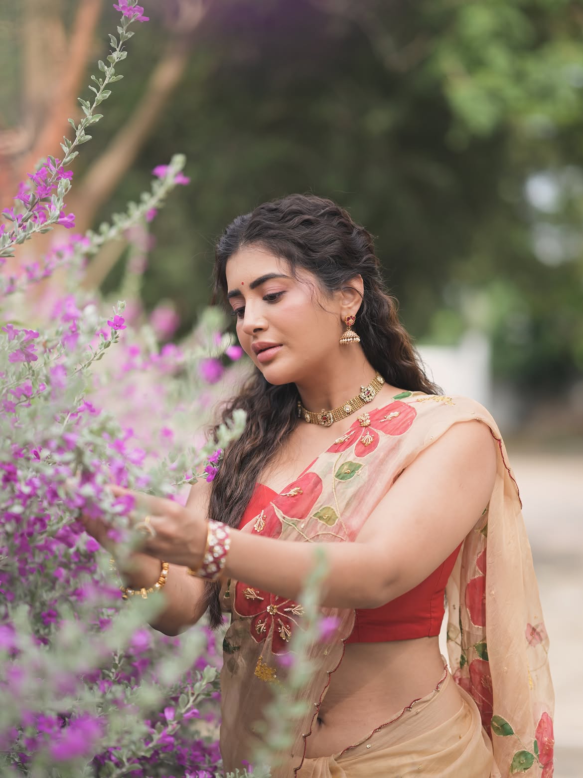 Rashi Singh Admiring Purple Flowers On A Bush