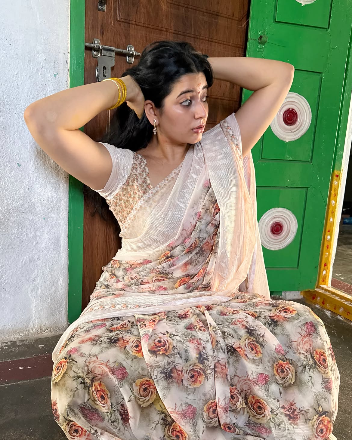 K Sudha Adjusts Her Dark Hair In An Ivory Sarees
