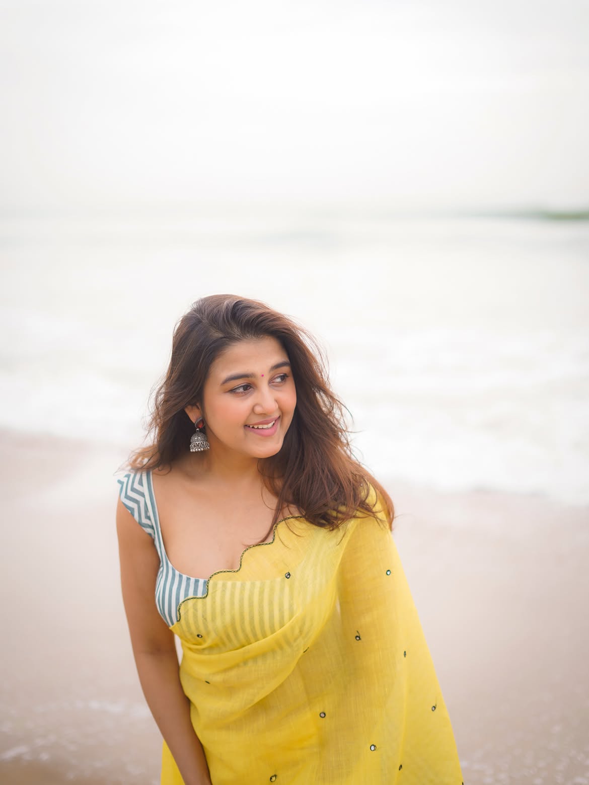 Sowmika Flaunts Her Yellow Saree Look At A Beach