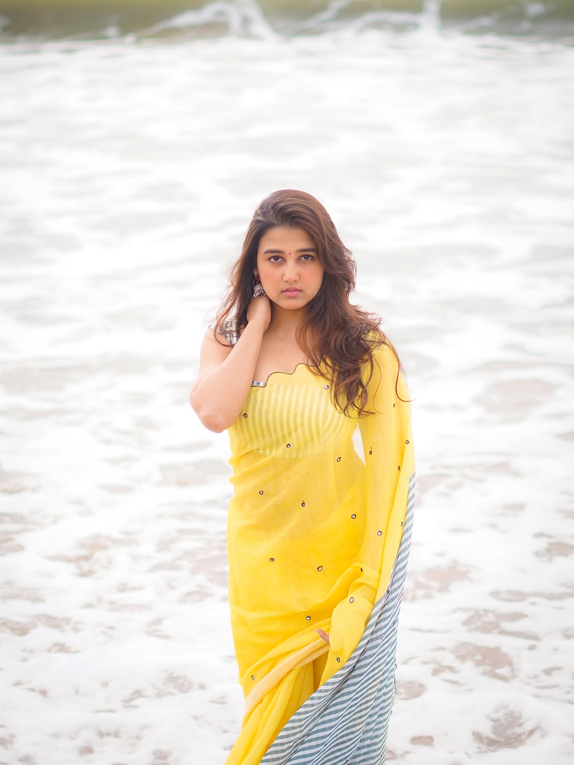 Sowmika Radiates Charm In Yellow Sari On A Beach