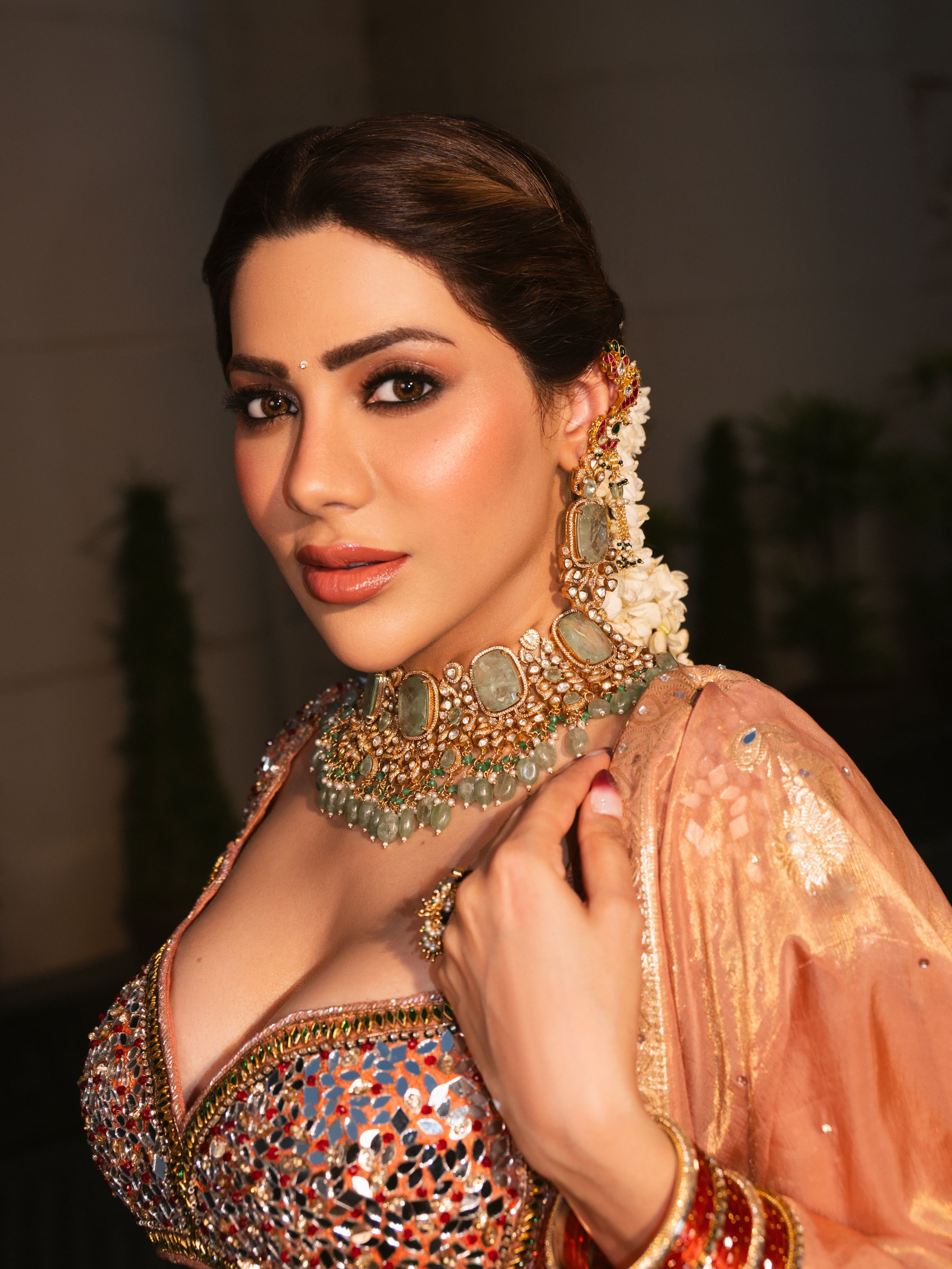 Nikki Tamboli Poses Wearing Red And Gold Bangles