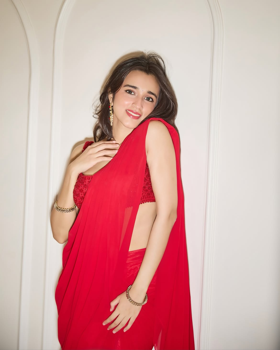 Nuveksha Holds The Red Saree Drape Near Her Face